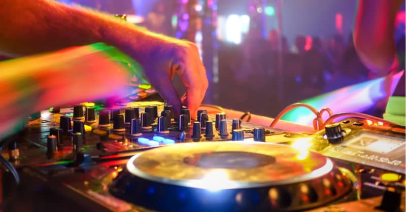DJ turntables under purple nightclub lights